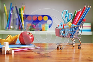 Back to School Shopping Cart with Supplies on Wooden Table.