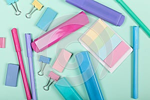 Back to school shopping concept. Pastel colored school supplies on paper background. Flat lay, top view, copy space.