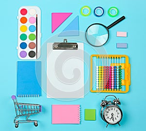 Back to school shopping concept. School supplies on blue background. Flat lay, top view, copy space.