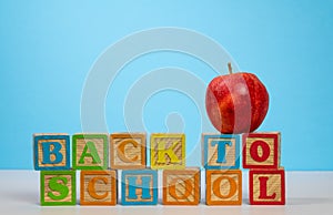 Back to School spelled out in wooden blocks with apple