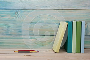 Back to school. Stack of colorful books on wooden table. Copy space