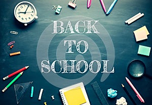 Back to school and  stationary supplies on blackboard background