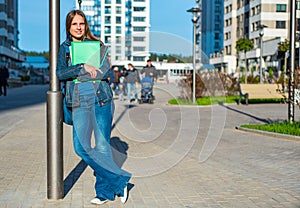 Back to school student teenager girl holding books and note books wearing backpack. Outdoor portrait of young teenager brunette gi