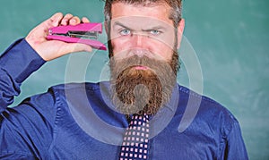 Back to school and studying. Teaching memorization techniques. Teacher bearded man with pink stapler chalkboard photo