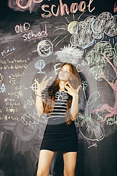 Back to school after summer vacations, cute teen real brunette girl in classroom at blackboard, lifestyle people concept