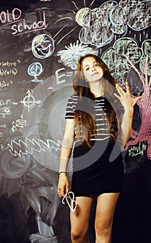 Back to school after summer vacations, cute teen real brunette girl in classroom at blackboard, lifestyle people concept