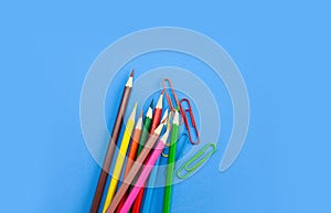 Back to school supplies concepts, Colorful pencils and clips on blue background with copy space