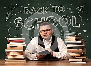 Back to school teacher sitting at classroom desk