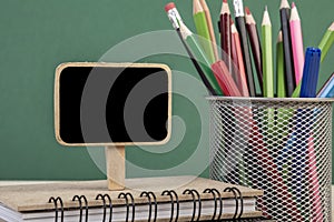Back to school template with a blank chalkboard over green background