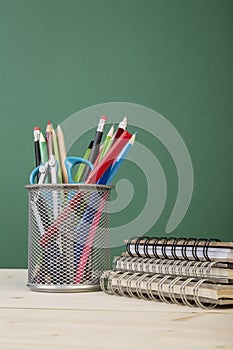 Back to school template with stationeries and books on table over green