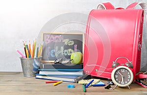 Back to school text on black chalk board with bag