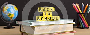 Back to school text with books and stationery over chalkboard