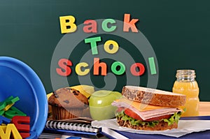 Back to school words text on classroom blackboard with packed lunch