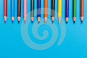 Back to scool - Pencils detail. Colored sharp pencils detail in a row, isolated on blue photo