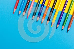 Back to scool - Pencils detail. Colored sharp pencils detail in a row, isolated on blue and yellow photo