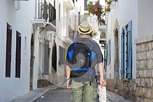 Back of traveling man holding map in town