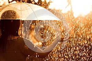 Back veiw of woman with umbrella in the rain and sunlight