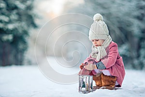 Back view of adorable girl with flashlight on Christmas outdoors