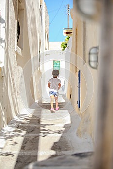 Back view of Adorable girl walking alone in narrow