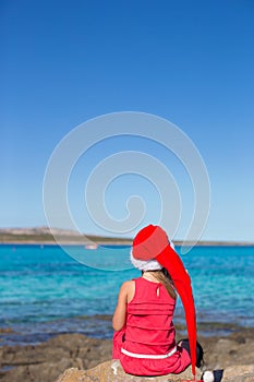 Back view of adorable little girl in Santa hat on