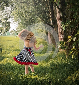 Back view adorable toddler outside in blue and white polka dots