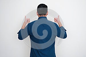 Back view of adult Asian man give two thumbs up photo