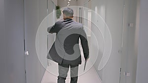 Back view adult businessman Asian ethnic man guy employer going to meeting at office hallway professional entrepreneur