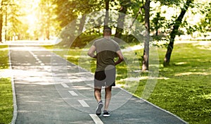 Back view of African American runner jogging at park on summer morning, blank space