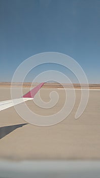 Back view of airplane wing with the blue sky background