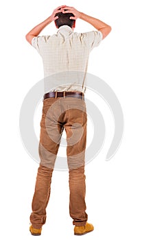 Back view of angry young man in jeans and shirt.