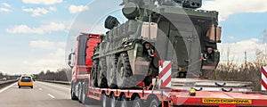 Back view armoured personnel carrier stryker with air defense system trailer hauler carrier truck drive military convoy