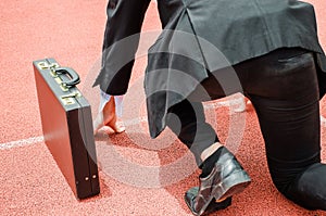 Back view of asian business man ready to run on the lanes of a track