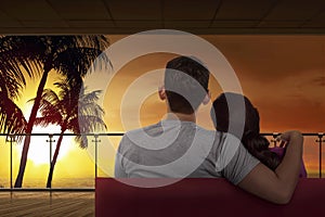 Back view of asian couple relaxing on couch and enjoying sunset