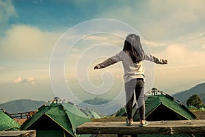 Back view of asian girl expand her arms in camping photo