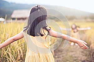 Back view of asian little child girl raise her hand