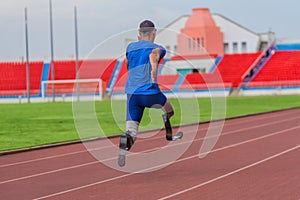 Back view of Asian male athlete with prosthetics sprints, aiming for record at speed running practice