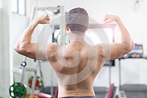 Back of view Asian men doing bodybuilder Rear Double Biceps pose in gym