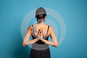 Back view of athletic woman stretching arm muscles