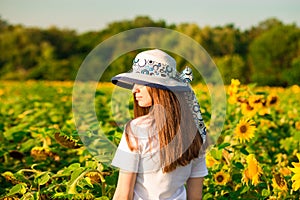 Back view of attractive young woman with long hair in sunflower field