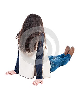 Back view beautiful curly woman sitting on floor and looks into