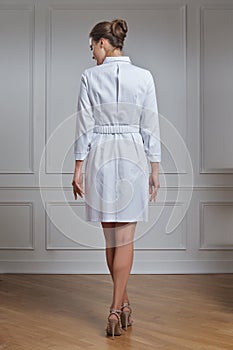 Beautiful female doctor in white clothes. Portrait of attractive medic in white robe