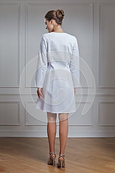 Beautiful female doctor in white clothes. Portrait of attractive medic in white robe