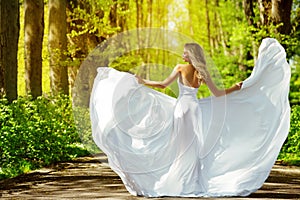 De hermosa chica en blanco ropa afuera. feliz una mujer en boda vestido lejos en amanecer callejón. despreocupado 