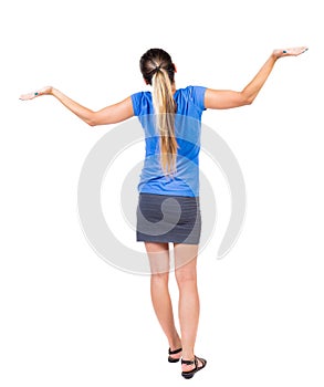 Back view of Beautiful woman in dress looking at wall and Holds