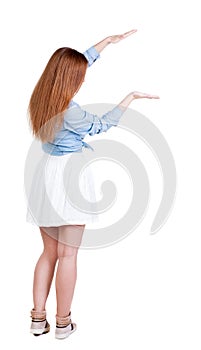 Back view of Beautiful woman in dress looking at wall and Holds