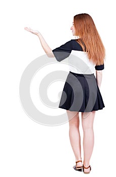 Back view of Beautiful woman in dress looking at wall and Holds