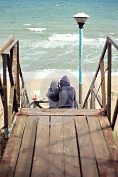 Back view of beautiful young couple holding hands hugging watching the sea on the beach Young couple in love. Attractive man and