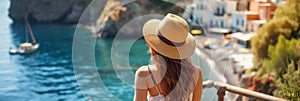 Back view of beautiful young woman admiring scenery while visiting small southern European town on sunny summer day. Banner with