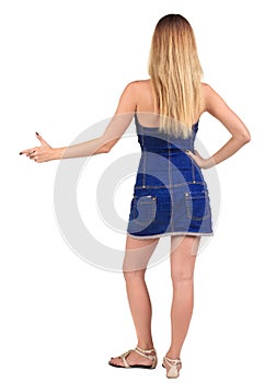 Back of view beautiful young woman in jeans dress pointing at w