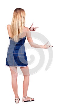 Back of view beautiful young woman in jeans dress pointing at w